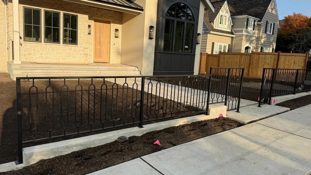Newly built home exterior with decorative metal railing and landscaped front yard.