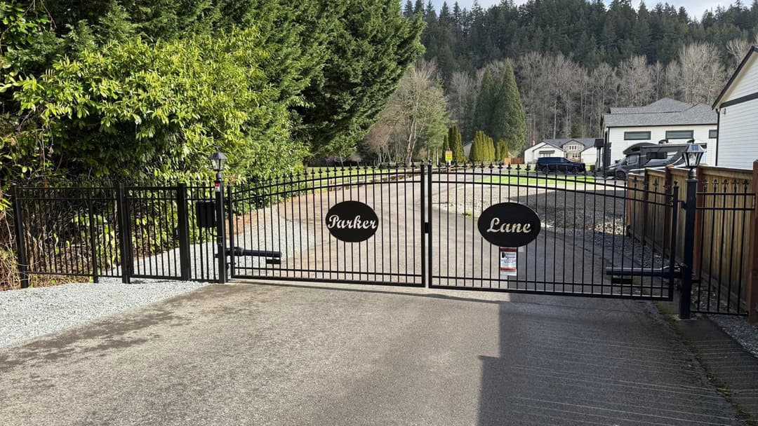 Black metal gate with "Parker Lane" signage, leading to a scenic residential area.