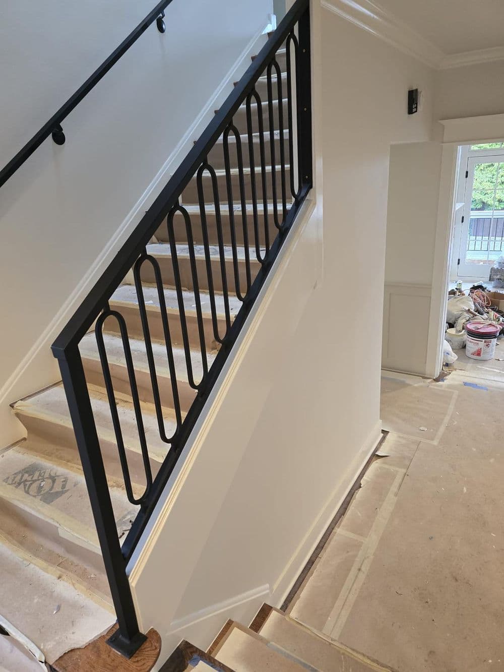 Staircase with modern black railing and freshly painted walls in a residential home.